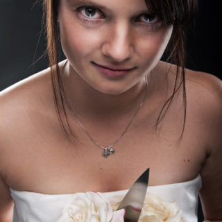 Anne beim Trash the Dress im Brautkleid mit einem Küchenmesser im Blumenstrauß